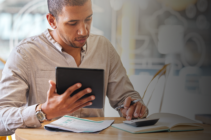 Young man in dress shirt working on Tablet.